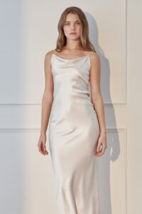 Front view of ivory Women's Silk Slip Dress with a soft glow and elegant draping silhouette.