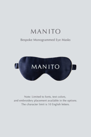 Navy blue bespoke monogrammed silk eye mask by MANITO displayed on a light background, featuring customization options for font, text color, and embroidery placement.