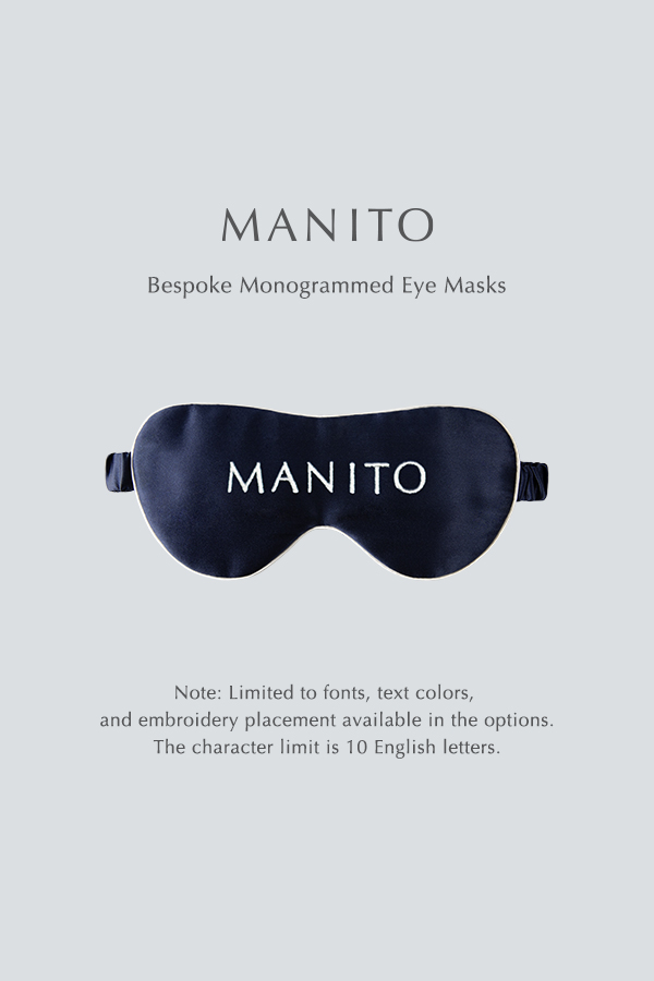 Navy blue bespoke monogrammed silk eye mask by MANITO displayed on a light background, featuring customization options for font, text color, and embroidery placement.