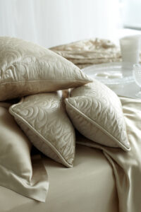 Elegant quilted silk pillows on a silk sheet, showcasing intricate stitching and luxurious texture.