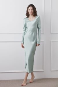 Model displaying Muses Silk Midi Dress in green with a sleek long-sleeve design.