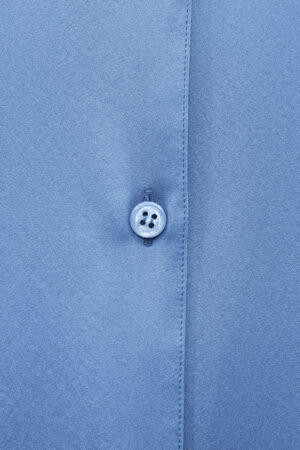 Close-up of the blue button and fine stitching on the Vibrant Silk Shirt.