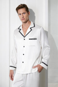 Dashing man in white Noir Ruban Men's Silk Pajama Set with elegant black piping detailing.