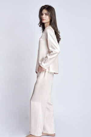 Model on Daisy Women's Pink Pajama Set, featuring a top with a ruffled collar and cuffs.