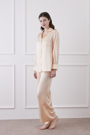 Side view of model in Orange Resort Women's Pajama Set, highlighting flowing silk wide-leg pants and clean lapel shirt.