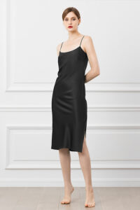 Woman wearing a sleek Classic Slip Dress in black silk with spaghetti straps.