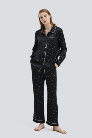 Woman wearing the Signature Women's Pajama Set in a chic black with contrasting white piping and playful print.