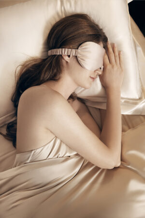 Model resting with a MANITO silk eye mask from the Eye Mask Renewal Subscription for gentle, comfortable sleep.
