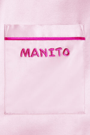 Close-up of the Manito logo embroidered on the pocket of a pink Macaron Silk Pajama Set.