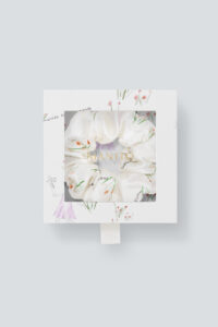 Close-up view of the Princess Louise Silk Scrunchie packaging featuring a floral design scrunchie visible through a clear package.