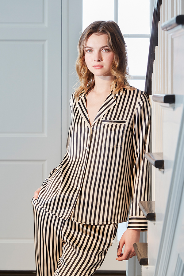 Woman in chic Stripe Silk Pajama Set with black and white patterned design.