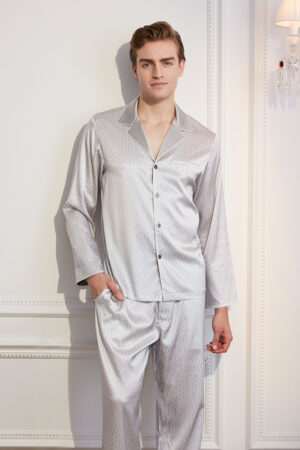 Sophisticated man modeling a classic monogram silk pajama set in white with monogram pattern.
