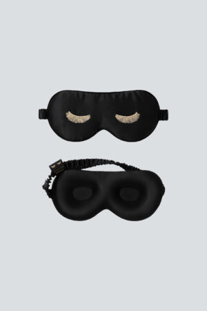 Front and back view of black Lash Contour Silk Eye Mask, featuring its ergonomic eye contours and gold eyelash embroidery.