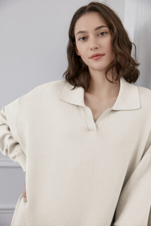 Woman in wunder silk-wool-cashmere tracksuit with polo collar and soft knit texture.
