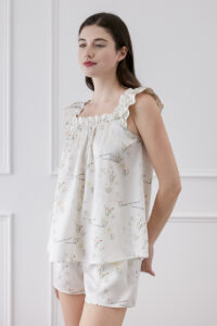 Woman displaying Princess Louise short pajama set with ruffle details.