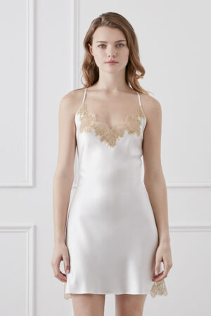 Elegant woman wearing wedding lace-trimmed silk slip dress with delicate spaghetti straps and smooth satin finish.
