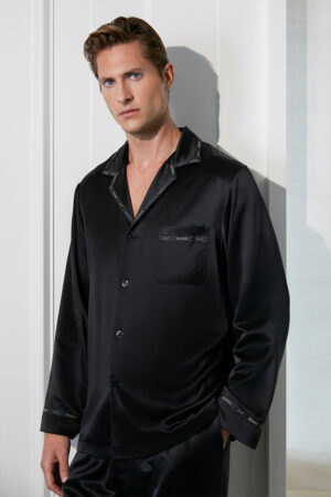 A man wears the black MANITO Noir Ruban Men's Silk Pajama Set with subtle contrasting dark trim.