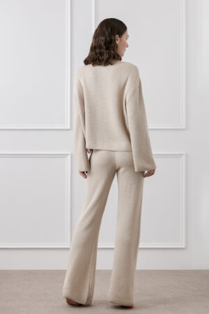 Back view of woman wearing Mellow Silk-Wool-Cashmere Lounge Set in sand taupe, showing loose silhouette and cozy knit texture.