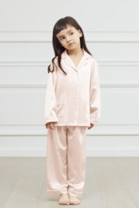 Young girl in a soft pink authentic silk pajama set looking happy.