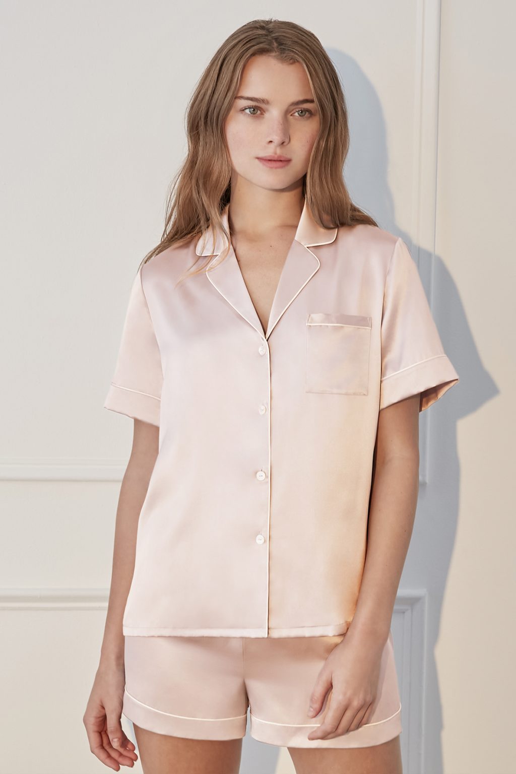 Woman wearing Authentic Silk Women's Short Pajama Set in pink with light piping.