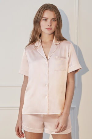 Woman wearing Authentic Silk Women's Short Pajama Set in pink with light piping.