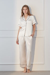 Model in ivory MANITO Authentic Short Sleeve Pajama Set with black trim, showcasing timeless elegance.