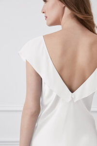 Back view of a Crete White Silk Midi Dress, highlighting the dress's fluid lines and graceful draping.