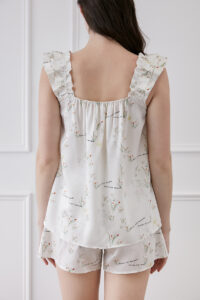 Back view of a woman in Princess Louise short pajama set with ruffle details and floral pattern.