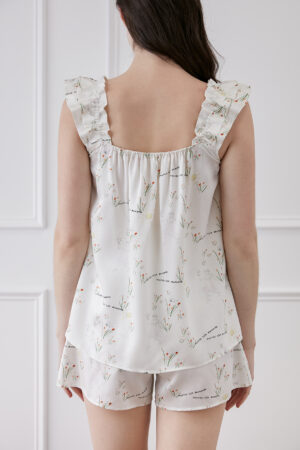 Back view of a woman in Princess Louise short pajama set with ruffle details and floral pattern.