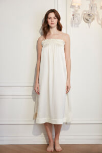 Model wearing Blooming Women's Silk Midi Slip Dress with ruffled neckline and adjustable spaghetti straps.