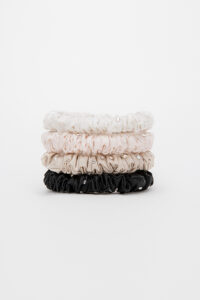 Stacked neutral-tone MANITO Twinkle Mulberry Silk Scrunchies in black, taupe, pink, and ivory.