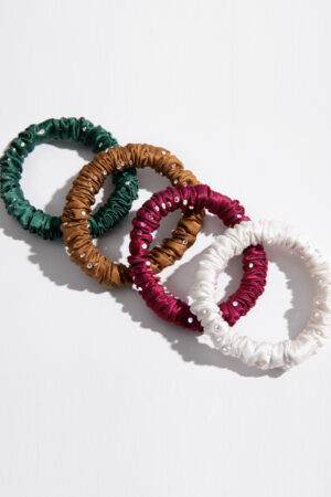 Colorful MANITO Twinkle Mulberry Silk Scrunchies in green, gold, red, and white with crystal details.