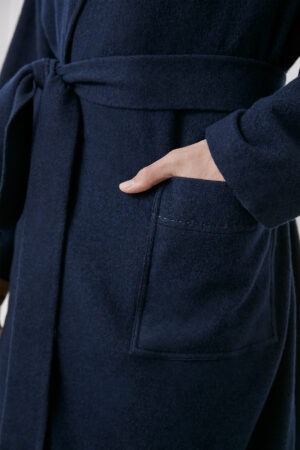 Model adjusting MANITO Bomber Men's Knit Robe, highlighting button and front pocket craftsmanship.