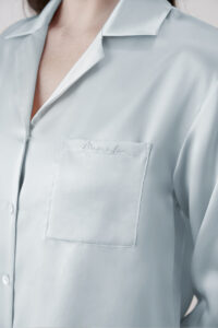 Close-up of Baby Blue Resort Women's Pajama Set showing chest pocket with subtle embroidered logo detail.