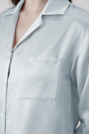 Close-up of Baby Blue Resort Women's Pajama Set showing chest pocket with subtle embroidered logo detail.