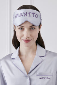 Close-up of a woman wearing a lavender Macaron Silk Eye Mask by MANITO, complemented by her silk pajama top.
