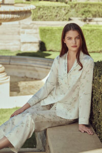 Princess Louise silky pajama set with floral pattern on a woman in serene garden setting.