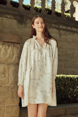 Woman in Princess Louise Silk Dress with garden-inspired prints and ruffle trim details.