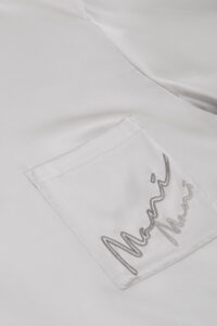 Close-up of the ivory pajama set's pocket detail, embroidered with MANITO logo on MANITO Remington Men's Short Sleeve Pajama Set.