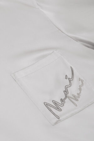Close-up of the ivory pajama set's pocket detail, embroidered with MANITO logo on MANITO Remington Men's Short Sleeve Pajama Set.