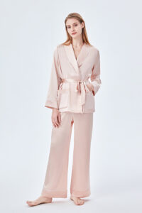 Model wearing MANITO Elite Women's Silk Robe Suit in pink, showcasing shawl collar, tie belt, and double-pocket design.