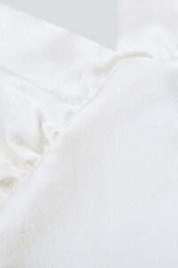 Close-up view of the luxurious silk fabric of an Essential Silk Slip Dress, highlighting the material's smooth texture.