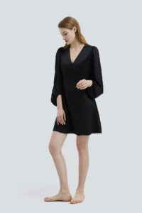 Sophisticated model in a Pure V-neck Lantern Sleeve Silk Mini Dress in classic black.