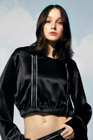 Woman in a front pose with a Sportif Silk Tracksuit featuring hood down and branded trim.