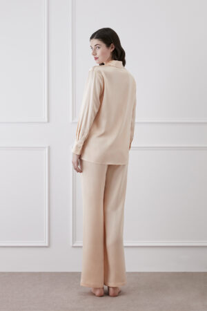 Back view of Resort Women's Pajama Set in Orange, showing long-sleeve lapel shirt and wide-leg silk trousers.