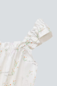 Close-up of the Princess Louise short pajama set in ivory with floral patterns.