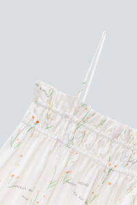 Detailed view of Princess Louise silk slip dress's strap and ruched neckline with delicate floral print.