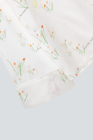 silky pajama set cuffs and hem detail with delicate floral and sun illustrations by 'mamito'.