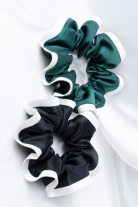 Close view of green and black Two-tone Silk Scrunchies highlighting smooth silk, elastic comfort, and low-friction wear.
