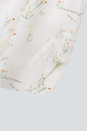 Close-up of the hem of Princess Louise silk slip dress featuring whimsical illustrations and 'manito' text.